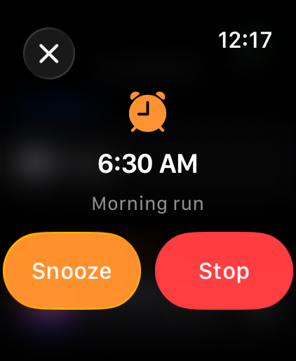 A phone alarm ringing on the watch with Snooze and Stop